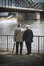 two older men looking at a bridge